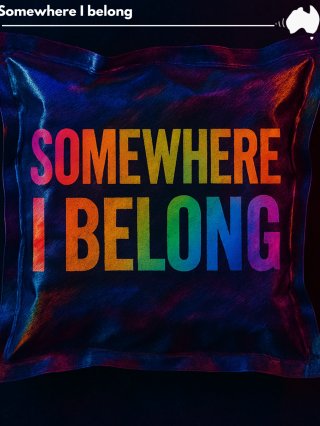Rainbow colourful text onto of a reflective pillow