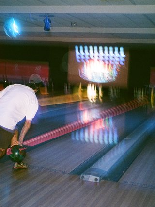 A blurry photo of a person bowling.