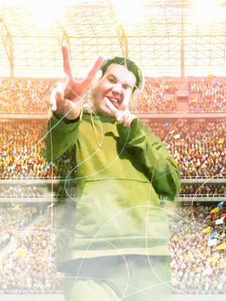 Jim crudely photoshopped into a soccer stadium. they're posing cutely while the crowds go crazy in the stands.