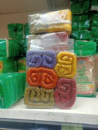 bundles of dried noodles coloured differently (one purple, yellow, red, brown and orange)