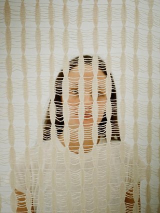 Rachel is behind a woven material and you can only see part of her face