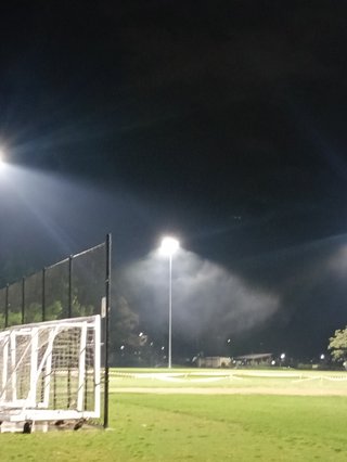 Lights on a football field capturing haze flowing