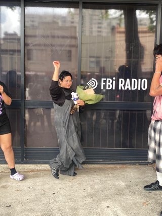 Shareeka stands out the front of fbi with flowers in hand semi dancing. The original Race Matters team Tanya and Darren are on either side of her