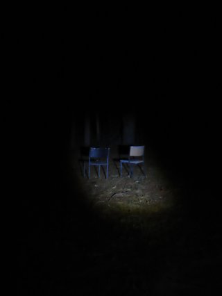 a photo of two chairs in the distance with a spotlight on the chairs