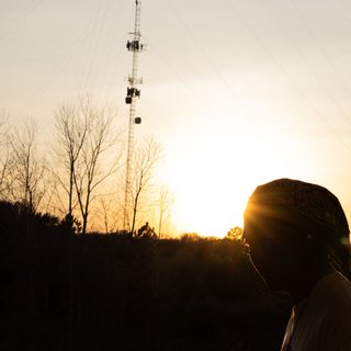album cover for heavensoulds - westside trapped, shows a person looking into the distance at a sunset