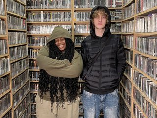 Chonzu pictured in the FBi Radio music library, standing next to 'Up for It' host Ify.