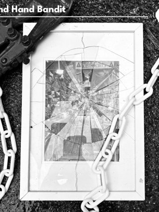 Broken glass from a picture frame which has a clamp attached to it and a chain going around it.