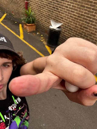 A high angle selfie of Giana walking in the street and pointing at the camera