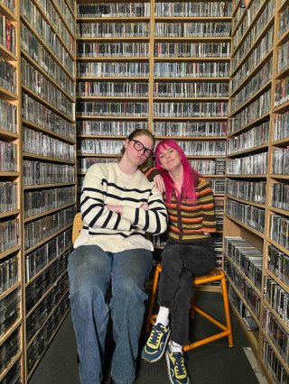Maddy and Kate sit in the Music library and pose