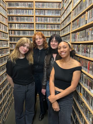 Jeanie, Heide, Gracie and Bri standing in front of the cd wall smiling