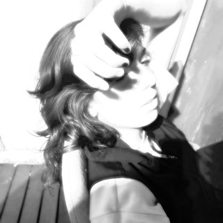 An overexposed, black and white profile of Kate, shot from the side. She is covering her forehead with her hand