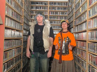 Mumfighter and Ella stand side by side in the fbi music library