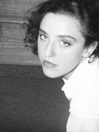 A black and white photo of Lilly wearing a white blouse and looking up at the camera.