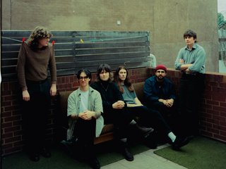 The six members of Coldwave sitting down on a bench. The member on the left is hung up on pegs on a washing line