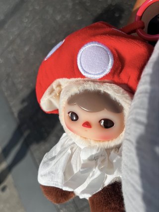 a plush toy of a little red mushroom person