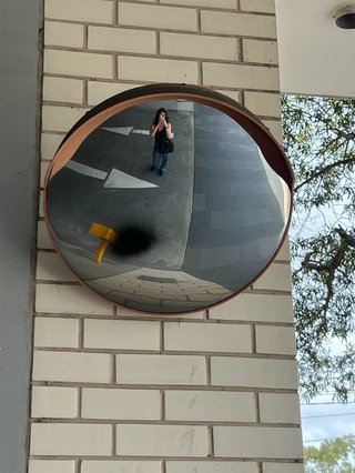 Louisa Christie taking an iPhone selfie in the concave mirror