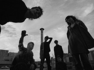 A  black and white image of the six members of Shock Corridor, cast slightly in shadow
