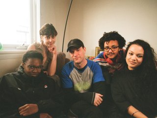 A warm film photo of the switch team sitting close together. from left to right: Cedar, Lau, Sandro, King and Sabrina