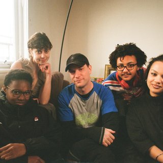 A warm film photo of the switch team sitting close together. from left to right: Cedar, Lau, Sandro, King and Sabrina
