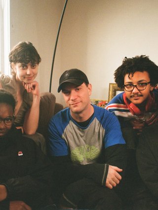 A warm film photo of the switch team sitting close together. from left to right: Cedar, Lau, Sandro, King and Sabrina