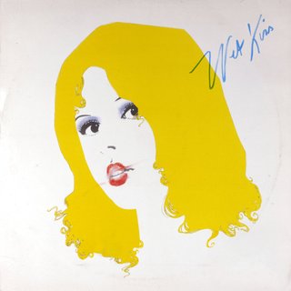 A drawing of a femme head on a white background. With yellow hair, red lips and blue eyes looking to the left. Wet Kiss is written in blue cursive in the top right corner
