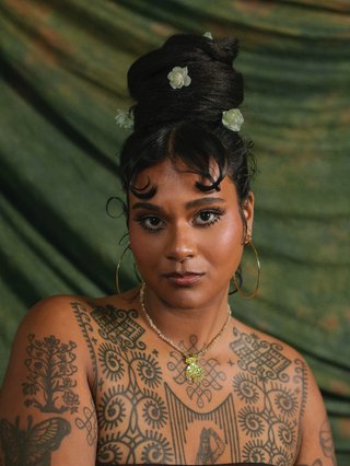 A portrait of Wild Gloriosa against a green backdrop.