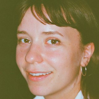 A closer up film photo, slightly faded yellow colour, of Astrid Sonne smiling