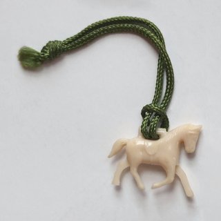 A white horse pendant attached to a thick, green string
