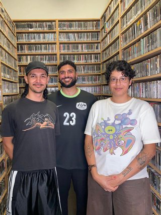 Michail, Karim and Saira stand in the fbi.radio CD collection room.