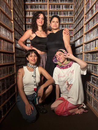 Roukayah Sara Shareeka and Toobs stand in the music library in staunch and sweet poses