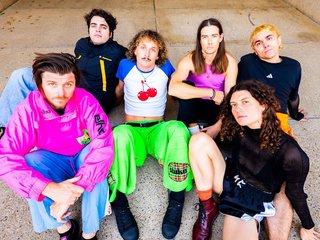The band Selve, all sitting on the ground.