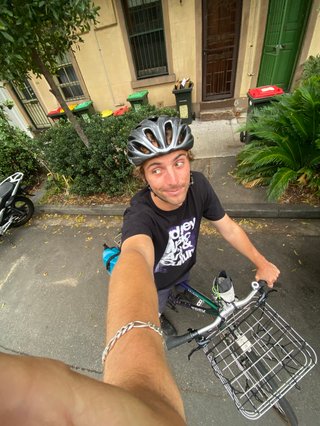 Selfie on a bike pulled over next to a curb and infront of terrace houses