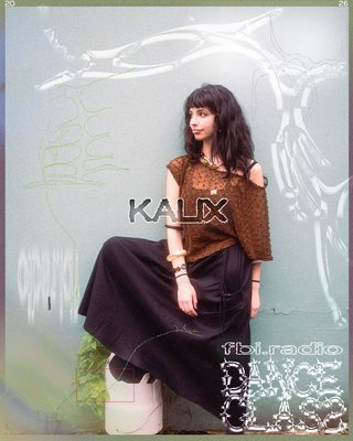 image of Kalix wearing brown, with a light blue background