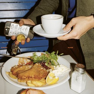 DJ Plead - Please, Album cover, Dj Plead behind a chicken schnitzel, near a sat shaker, holding a cup of coffee/tea and keys and small bottle.