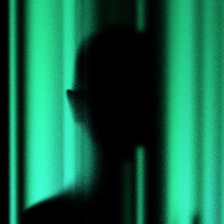 green and black background with a shadow of a person in the middle of the image
