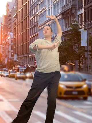 Jim edited in front of a city background. They are hitting a pose from the choreography of ILLIT's song "You're Under Arrest".