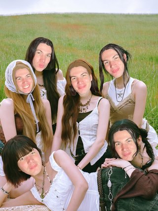 A picture of six girls (the members of girl group PURPLE KISS) sitting on grass. Jim's face has been poorly edited onto each of the girls.