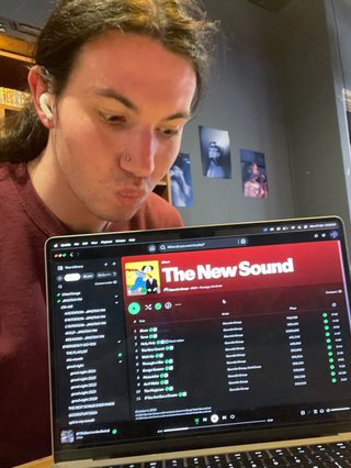 A selfie of Jim staring lovingly at their laptop which is showing the album The New Sound by Geordie Greep.