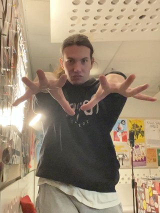 Jim standing menacingly, reaching two hands out with fingers outstretched directly towards the camera.