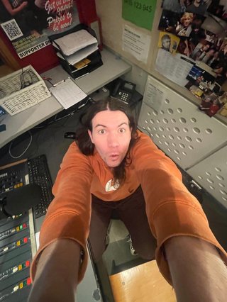 A 0.5x selfie taken in the studio from a very high angle of Jim with a wide mouth and wide eyes.