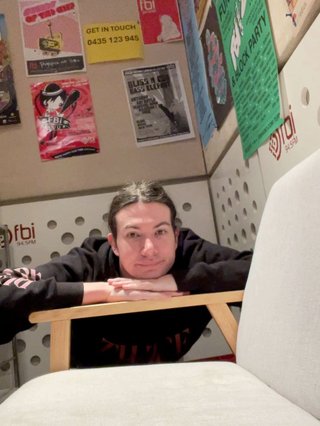 Jim leaning their chin on the arm of the couch in the fbi studio.