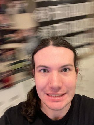 A slightly unnerving selfie of Jim staring into the camera with a crazed smile on their face.