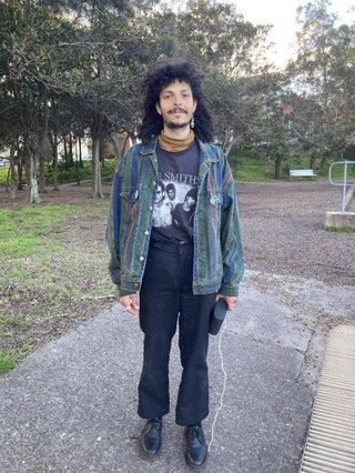 Tommy holding a speaker in a park in Rozelle!