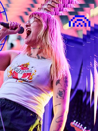 Parquet Courts frontman A. Savage staring at the camera holding his acoustic guitar, black and white photo